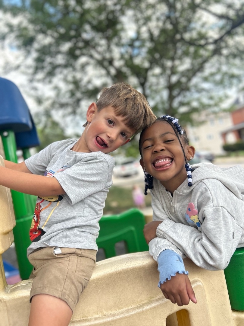 Children smiling together on the Brookline Sprouts playground