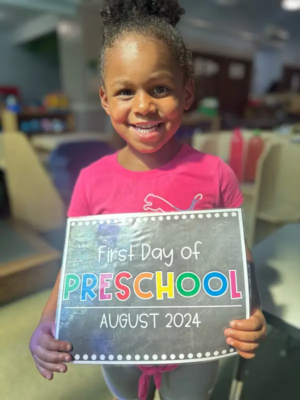 Child holding a first day of preschool sign at Brookline Sprouts